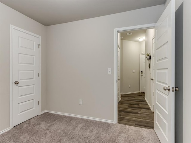carpeted empty room featuring baseboards