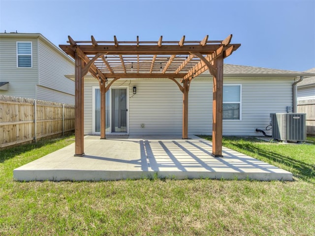 rear view of house with central AC unit, a pergola, a patio area, and a shingled roof