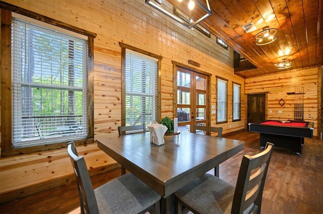 dining space with wooden ceiling, a healthy amount of sunlight, wood finished floors, and wooden walls