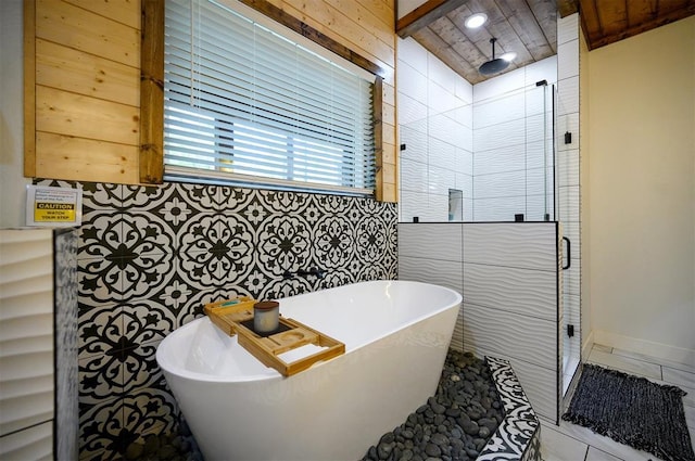 full bath with a freestanding bath, tile walls, and a stall shower