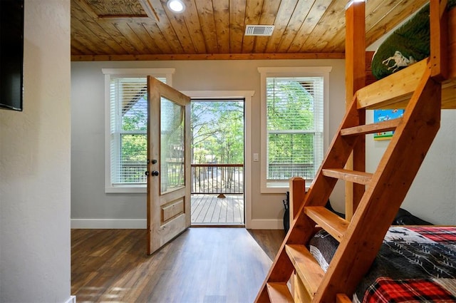 doorway with wood ceiling, baseboards, wood finished floors, and visible vents
