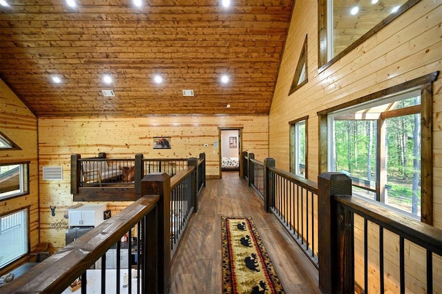 hallway with high vaulted ceiling, wooden ceiling, hardwood / wood-style floors, and wooden walls