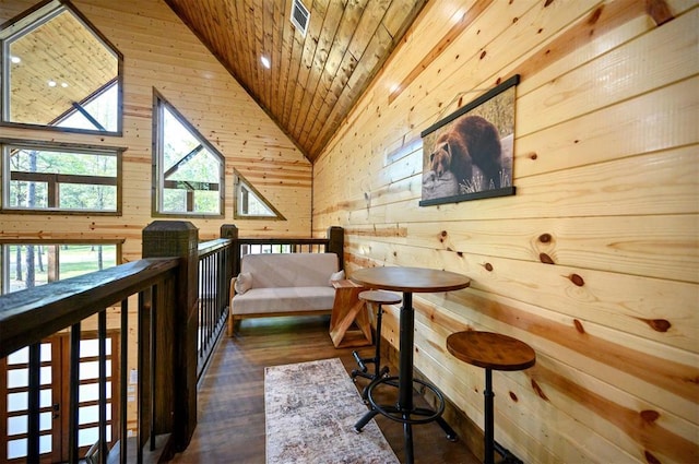 sitting room featuring wood ceiling, wood finished floors, wood walls, and lofted ceiling