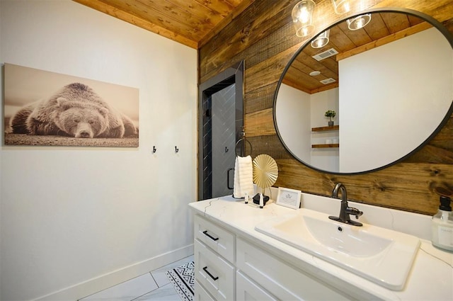 bathroom with baseboards, wooden ceiling, visible vents, and vanity