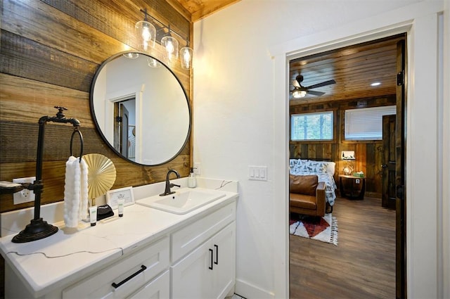 bathroom featuring wood finished floors, a ceiling fan, wood walls, and vanity