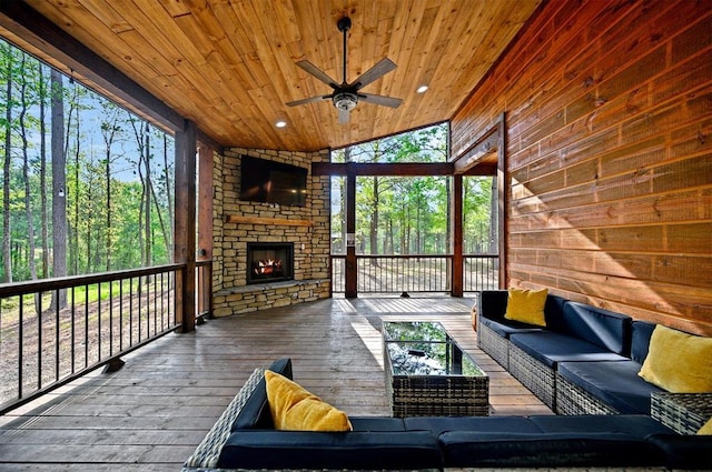 sunroom / solarium featuring an outdoor living space with a fireplace and a ceiling fan