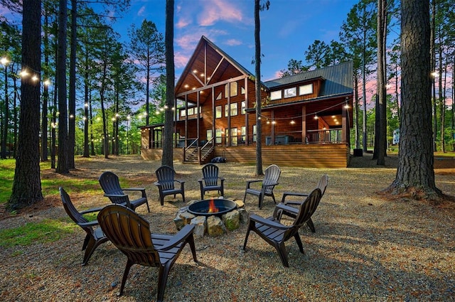 back of house at dusk with a fire pit