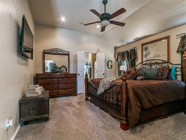 bedroom with vaulted ceiling, a textured wall, a ceiling fan, and carpet flooring
