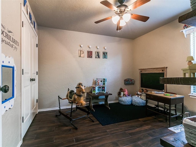 interior space with a textured wall, ceiling fan, and wood finished floors