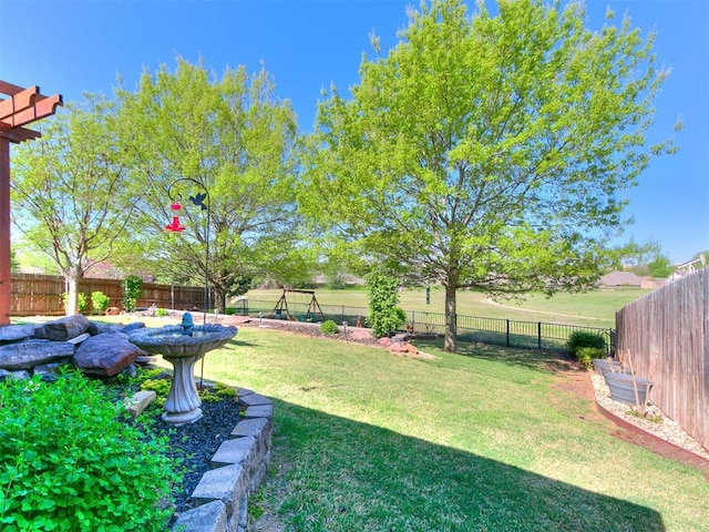 view of yard featuring a fenced backyard and a playground