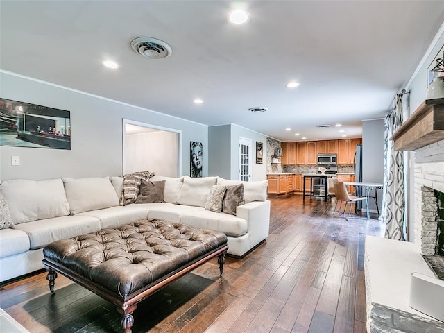 2813 Clermont Pl, Oklahoma City, OK 73116 - living room featuring recessed lighting, a brick fireplace, dark wood-style floors, and crown molding