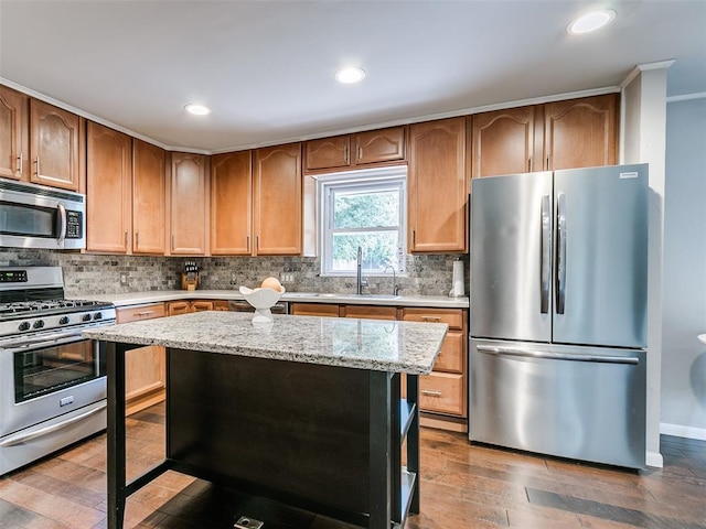 2813 Clermont Pl, Oklahoma City, OK 73116 - kitchen featuring stainless steel appliances, tasteful backsplash, light stone countertops, wood finished floors, and recessed lighting