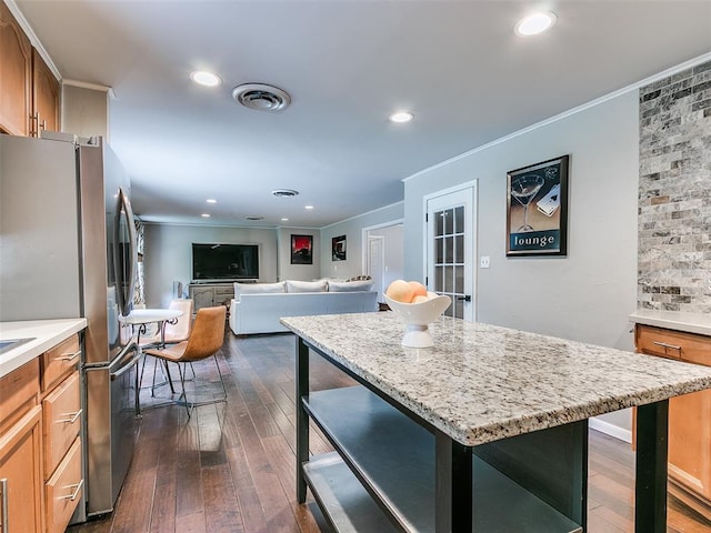 2813 Clermont Pl, Oklahoma City, OK 73116 - kitchen featuring a kitchen breakfast bar, freestanding refrigerator, dark wood-style flooring, crown molding, and a kitchen island