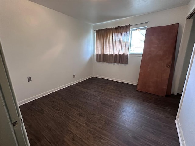 unfurnished bedroom featuring dark wood finished floors and baseboards