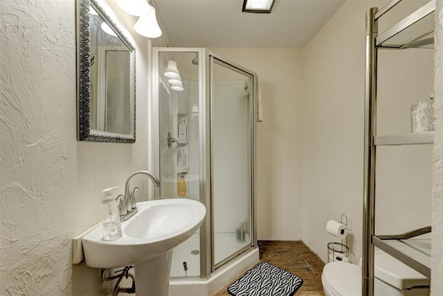 19206 Coker Rd, Shawnee, OK 74801 - full bathroom featuring a shower stall, toilet, a sink, and a textured wall