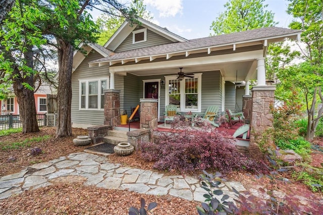 view of front of home featuring a porch, ceiling fan, roof with shingles, and fence