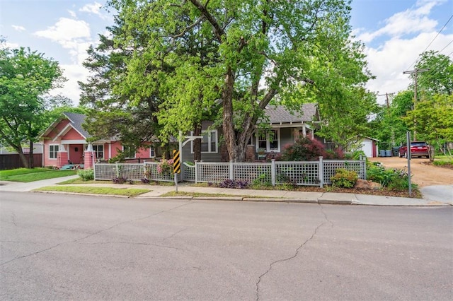 obstructed view of property with a fenced front yard, concrete driveway, and a garage