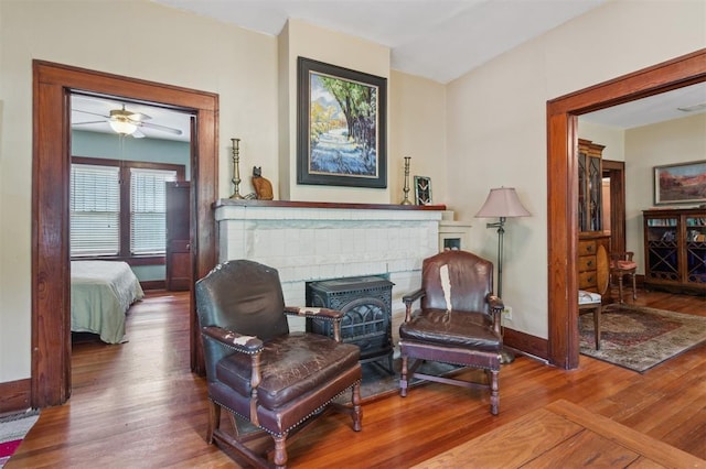sitting room with wood finished floors, baseboards, and a fireplace