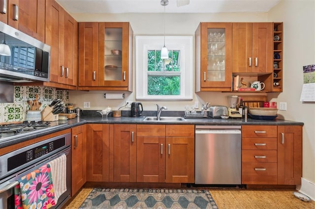 kitchen featuring stainless steel appliances, a sink, and brown cabinets
