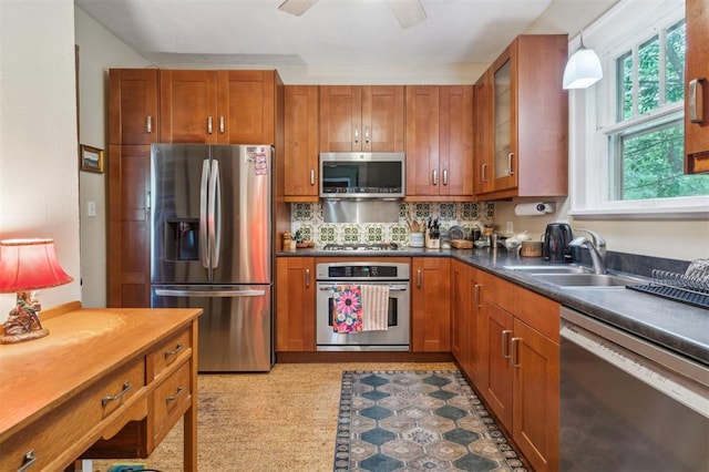 kitchen featuring appliances with stainless steel finishes, a sink, and brown cabinets