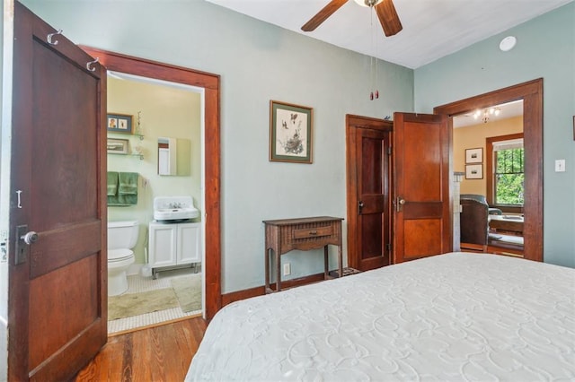 bedroom featuring wood finished floors, ensuite bathroom, and ceiling fan