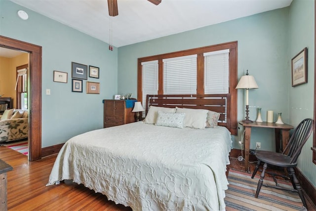 bedroom featuring wood finished floors, baseboards, and a ceiling fan