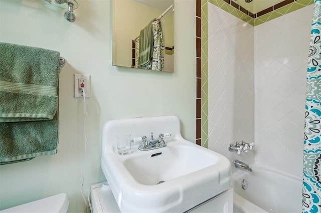 bathroom with a sink, toilet, and shower / bath combo