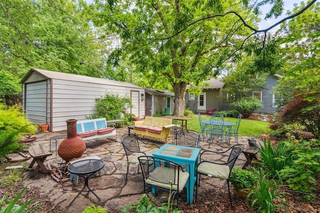 view of patio / terrace with an outdoor hangout area, an outdoor structure, and outdoor dining space