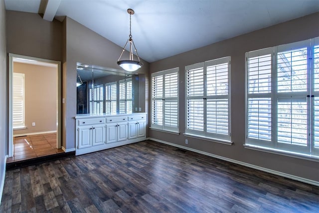 unfurnished dining area featuring vaulted ceiling, dark wood-style floors, and a wealth of natural light