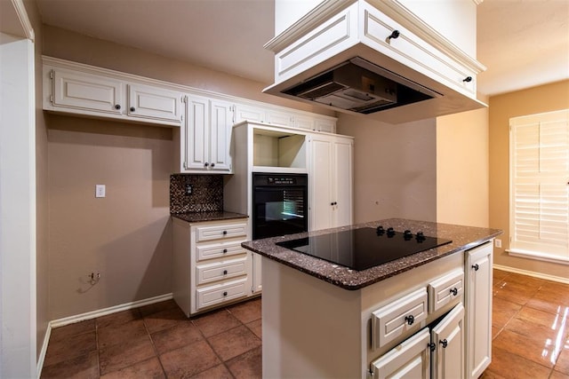 kitchen featuring white cabinets, dark stone counters, baseboards, dark tile patterned floors, and black appliances