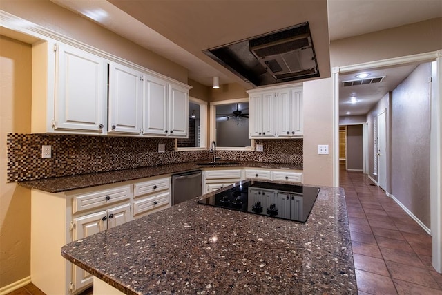 kitchen featuring visible vents, black electric stovetop, a center island, white cabinetry, and a sink