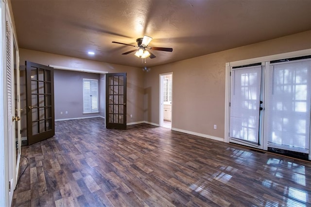 empty room featuring french doors, baseboards, ceiling fan, and dark wood-style floors