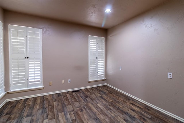 spare room with recessed lighting, baseboards, plenty of natural light, and wood finished floors
