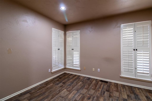 empty room featuring recessed lighting, baseboards, and wood finished floors