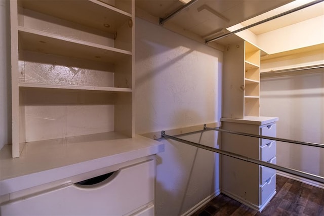 spacious closet with dark wood finished floors