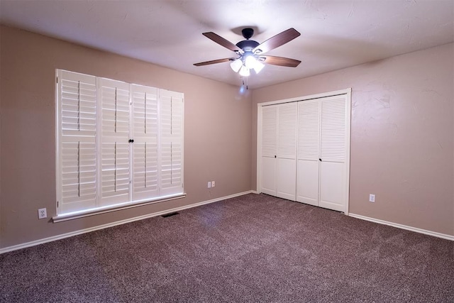 unfurnished bedroom with dark carpet, a ceiling fan, baseboards, and a closet