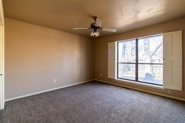 carpeted empty room featuring baseboards, plenty of natural light, and ceiling fan