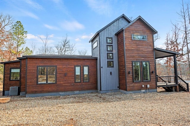 rear view of property featuring crawl space and cooling unit