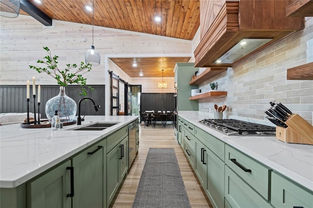 kitchen featuring appliances with stainless steel finishes, a barn door, a sink, lofted ceiling, and green cabinets