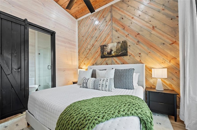 bedroom featuring wooden walls, connected bathroom, lofted ceiling with beams, a barn door, and wood ceiling