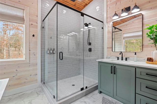 full bath featuring wood walls, marble finish floor, a stall shower, and a healthy amount of sunlight