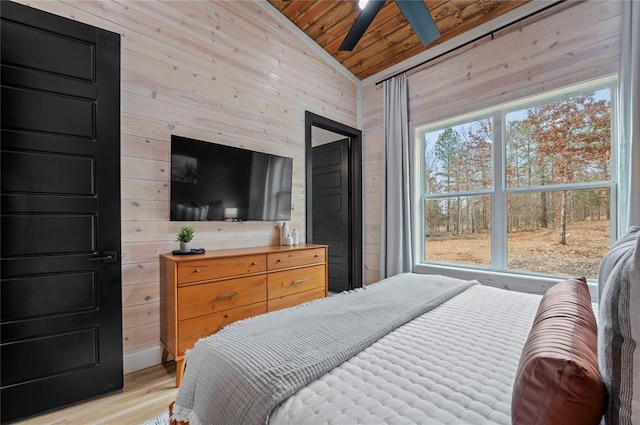 bedroom with wooden ceiling, light wood finished floors, vaulted ceiling, and wood walls