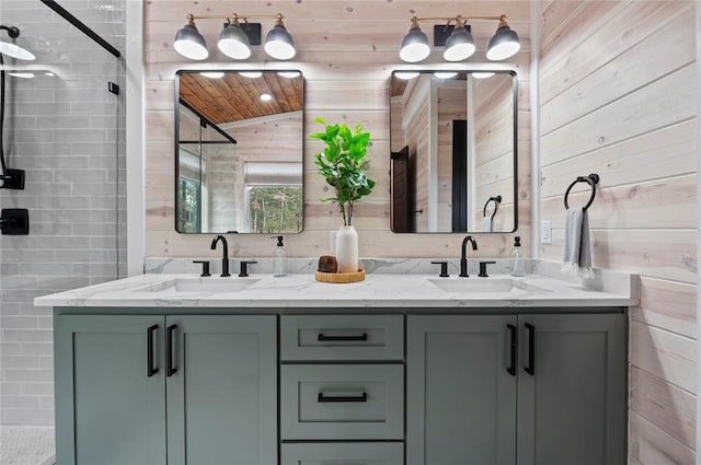 bathroom featuring a sink, tiled shower, wood walls, and double vanity