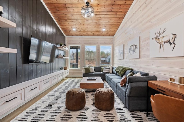 living room with wooden walls, wood ceiling, recessed lighting, and light wood-style flooring