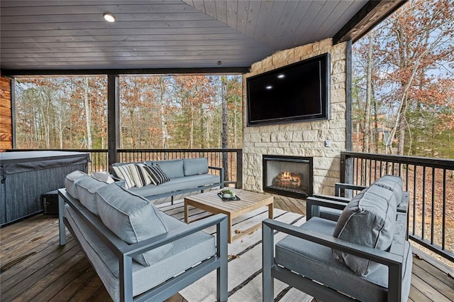 wooden deck featuring a hot tub and an outdoor living space with a fireplace