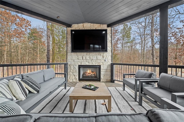 sunroom featuring an outdoor living space with a fireplace