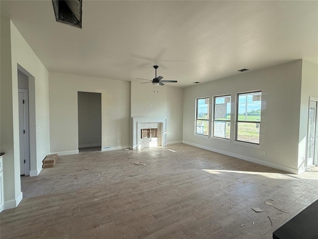 2706 Belle Crossing Dr, Enid, OK 73703 - unfurnished living room with a fireplace, a ceiling fan, baseboards, and wood finished floors
