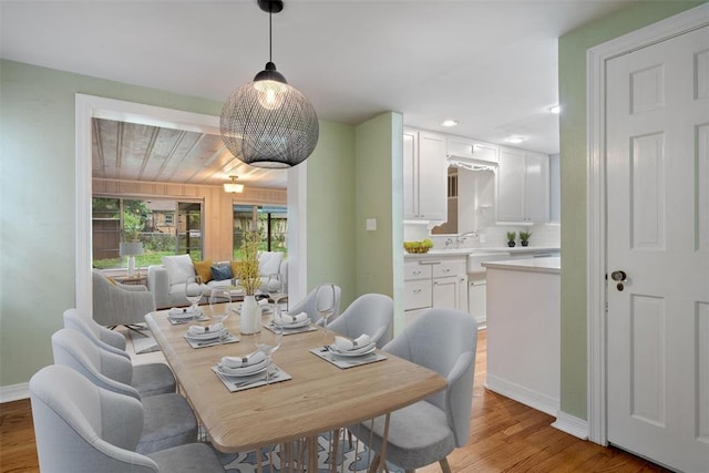 dining area featuring light wood-style floors, baseboards, and recessed lighting