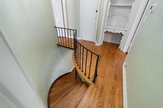 staircase featuring baseboards and wood finished floors