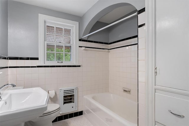 full bathroom featuring tile walls, a sink, tile patterned floors, toilet, and heating unit